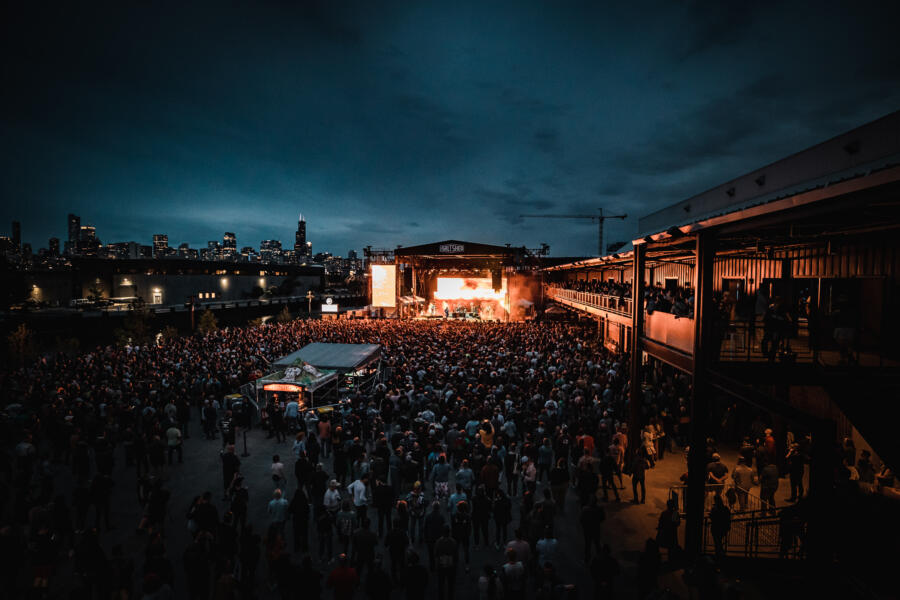An evening concert outside The Salt Shed with the Chicago skyline in the background